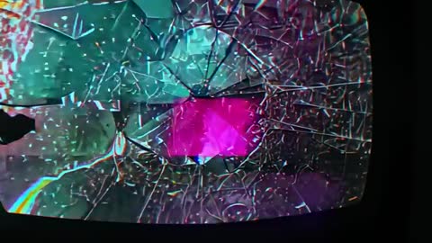 Shattered CRT with Glitch Artifacts and Pink Glow in Dim Room