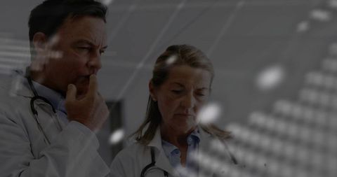 Senior doctors analyzing digital interface in modern clinic