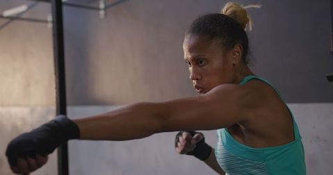 Focused athletic woman in boxing training at gym