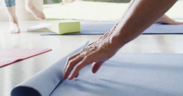 Person Rolling Up Yoga Mat After Fitness Session - Download Free Stock Images Pikwizard.com