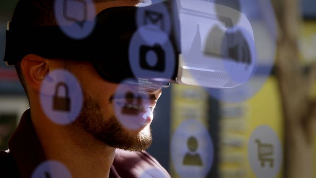 Caucasian businessman using VR headset with various digital icons overlay, representing an advanced technological environment. This suggests ideas of innovation and immersive experience, useful for promotions related to tech products, software development, future technology presentations, and interactive experiences.