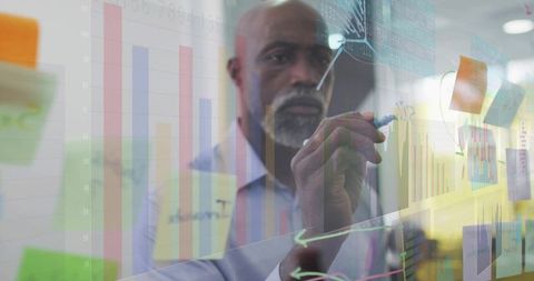 African American Executive Drawing Data Charts on Glass Board for Strategy and Innovation