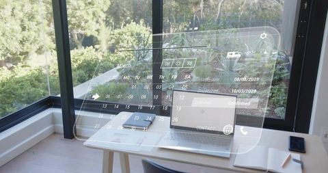Displaying open laptop with holographic calendar overlay in home office near glass window