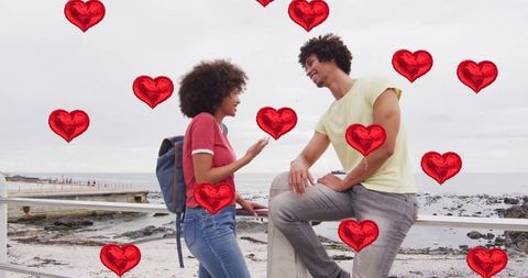 Romantic Couple by Coastal Walkway with Floating Hearts