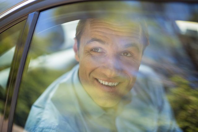 Smiling man looking through car window