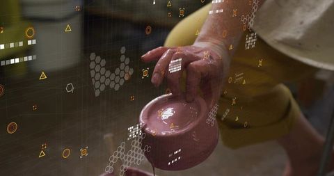 Potter placing wet clay pitcher on cup with augmented reality interface overlay