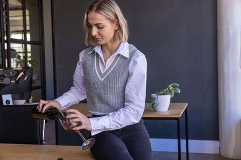 Woman Relaxing with Red Wine in Contemporary Home Office