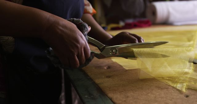 Close-Up of Hands Cutting Yellow Fabric with Scissors - Download Free Stock Images Pikwizard.com