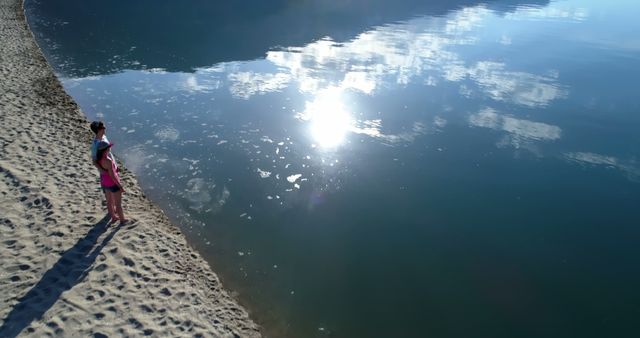 Woman Standing Alone on Sandy Beach by Tranquil Lake - Download Free Stock Images Pikwizard.com