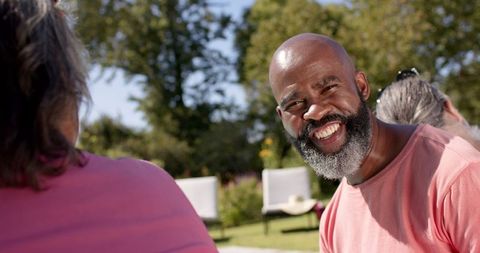 Man Smiling During Outdoor Chat with Friends in Garden