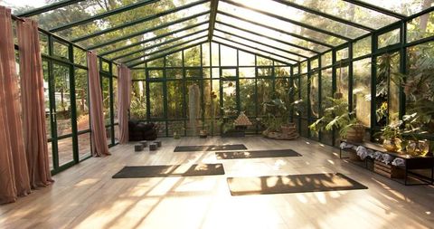 Tranquil Glasshouse Yoga Space Surrounded by Nature for Wellness and Meditation