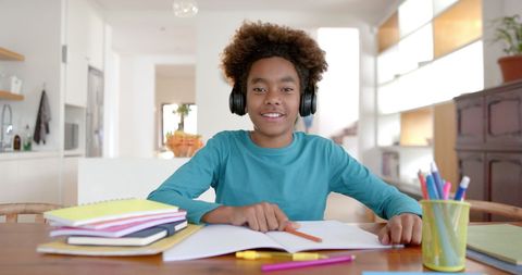 Smiling Boy with Headphones Studying at Home