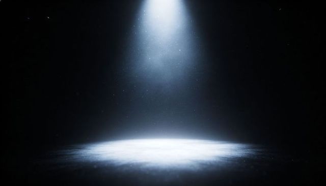 Dramatic Overhead Spotlight Casting Circular Light Pool with Visible Dust Motes on Dark Stage