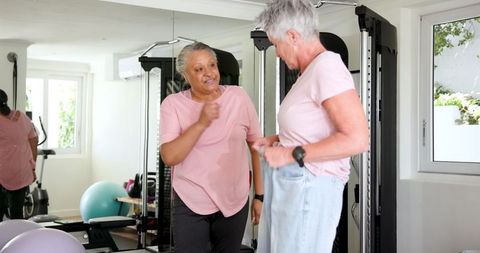 Diverse Senior Couple Celebrating Fitness Success at Home Gym