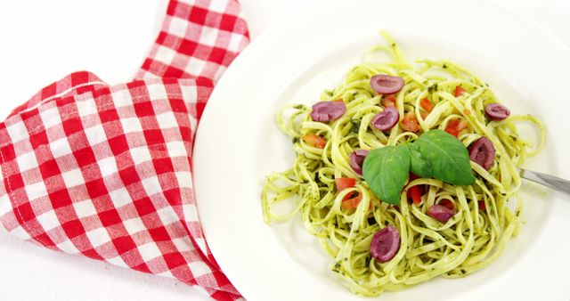 Linguine Pesto with Olives and Basil Garnish on White Plate - Download Free Stock Images Pikwizard.com