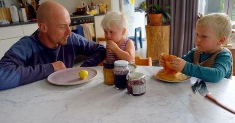 Father and Young Children Enjoying Meal Together at Home