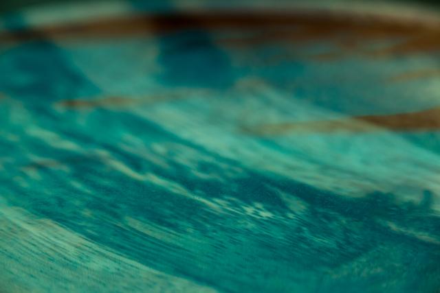This image captures a close-up view of ripples in water, showcasing abstract patterns and textures in shades of blue and green. Ideal for use in nature-themed projects, backgrounds, or designs emphasizing fluidity and motion.