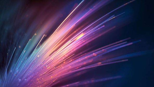 Glowing neon fiber burst radiating multicolor bokeh and dynamic light trails