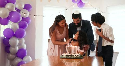 Happy Family Celebrating Tradition Around Cake with Candles