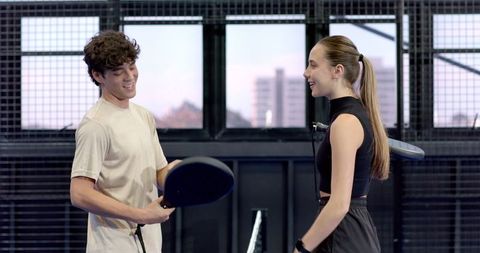 Young Friends Chatting on Indoor Padel Court with Rackets