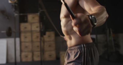 Athletic man skipping rope in gym cross training routine