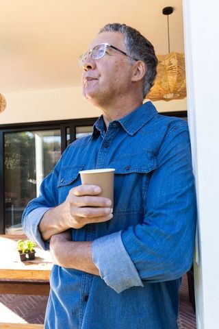 Middle-aged man enjoying coffee outdoors in relaxed atmosphere