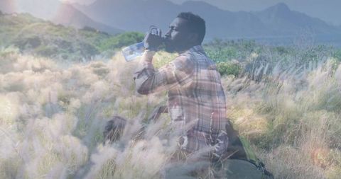 Hiker Hydrating in Lush Mountain Meadow with Backpack
