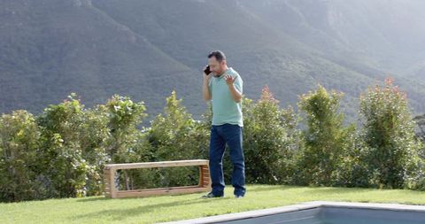 Man Contemplating Outdoors while Using Smartphone beside Pool