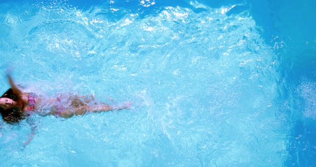 Woman swimming in clear blue water of tropical pool - Download Free Stock Images Pikwizard.com