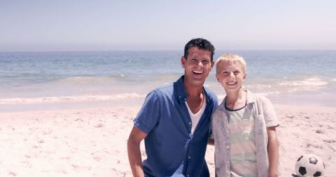 Father and Son Enjoying Beach Soccer on Sunny Day