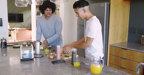 Male Friends Cooking Together at Modern Kitchen Island