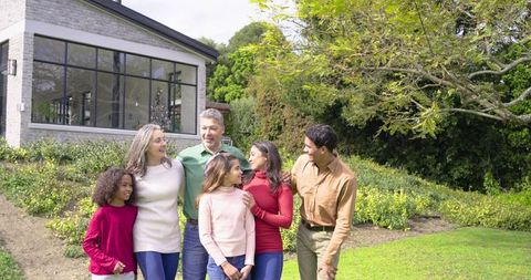 Multigenerational Diverse Family Enjoying Front Lawn by Modern Glass-Front Home