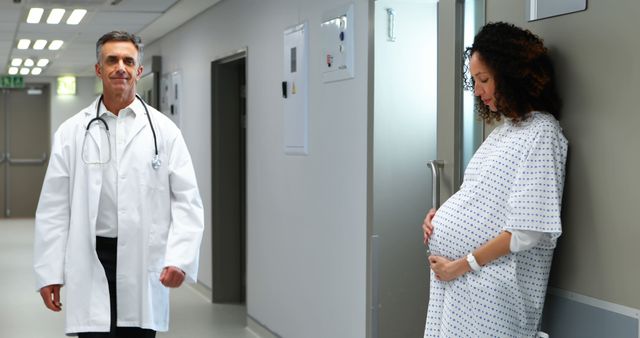 Pregnant Woman in Hospital Corridor with Doctor Approaching - Download Free Stock Images Pikwizard.com