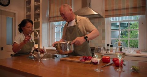 Senior Couple Cooking Together in Modern Kitchen With Fresh Vegetables