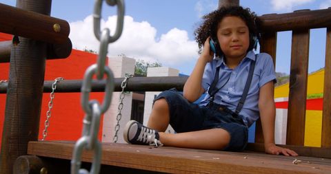 Young Boy Relaxing on Playground with Headphones - Download Free Stock Images Pikwizard.com