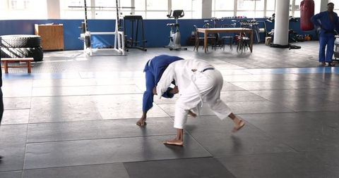 Martial Artists Practicing Grappling Techniques on Tatami Mats