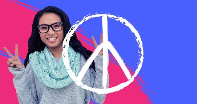 Joyful young woman, casually dressed in a sweater and scarf, smiling and showing peace signs with both hands. Colorful blue and pink background adds a vibrant and modern feel. Ideal for use in campaigns promoting peace, diversity, positivity, and social equality. Perfect for websites, posters, social media posts, or advertisements aiming to spread a positive message.