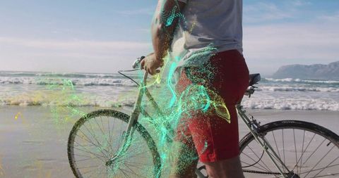 Man standing with bicycle on beach with futuristic digital effects