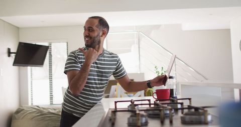 Joyful Man Using Tablet in Modern Kitchen