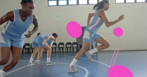 Female athletes sprinting in basketball drill on indoor gym court wearing blue kits