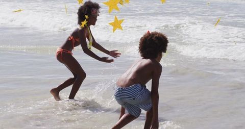 Siblings Playing Joyfully in Shallow Ocean Waters