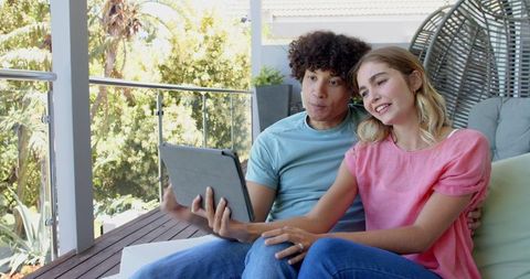 Young Couple Using Tablet on Porch for Video Call