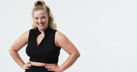 Confident plus size woman posing in studio in bright white background