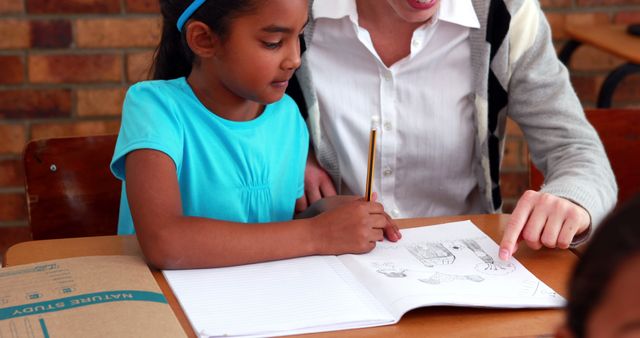 Teacher Assisting Young Girl with Schoolwork in Classroom Setting - Download Free Stock Images Pikwizard.com