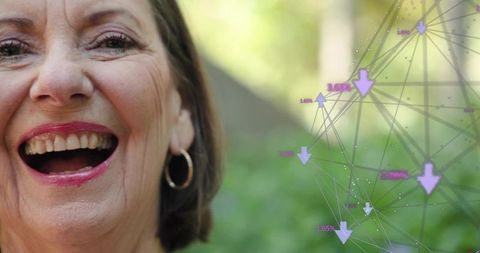 Laughing senior woman wearing pink lipstick and gold hoop earring sunny garden closeup