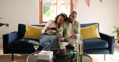 Diverse Couple Celebrating at Home with Cake and Wine