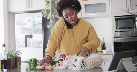 Busy Woman Unpacking Groceries in Kitchen Multitasking