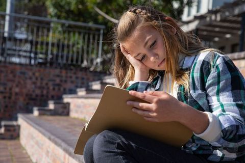 Young Artist Thinking on Outdoor Steps with Sketchpad