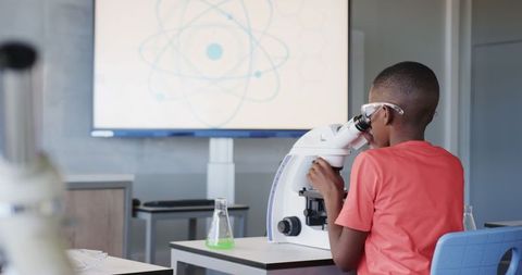 Young Scientist Using Microscope for Research Activity