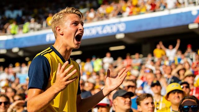 Young football fan shouting and gesturing in packed stadium crowd